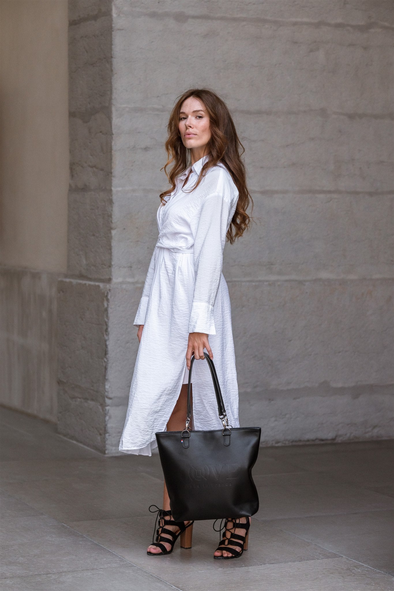 Grand sac cabas cuir porté main par une femme en robe blanche