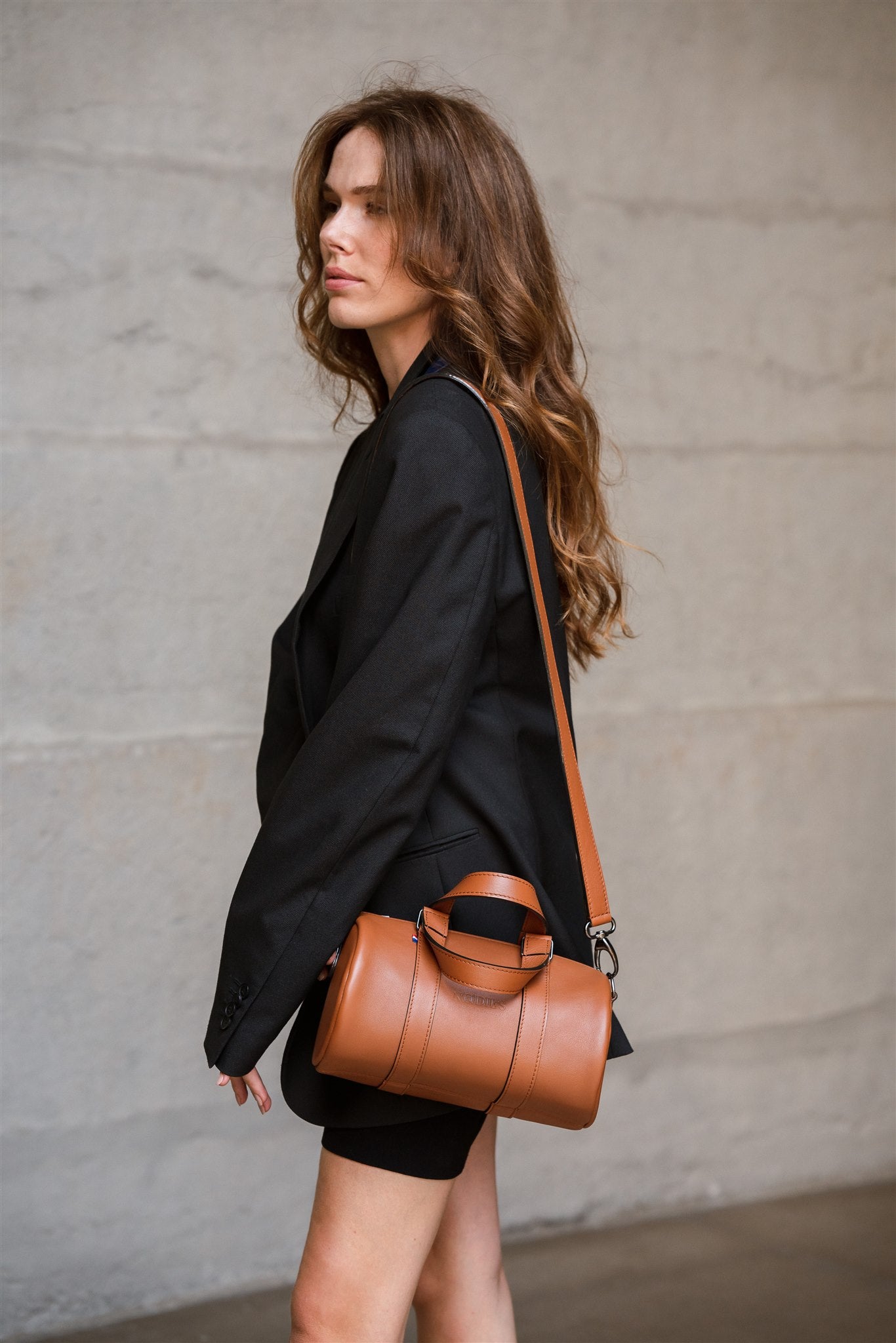 Sac bowling femme haut de gamme porté en bandoulière par une femme dans une tenue de style 